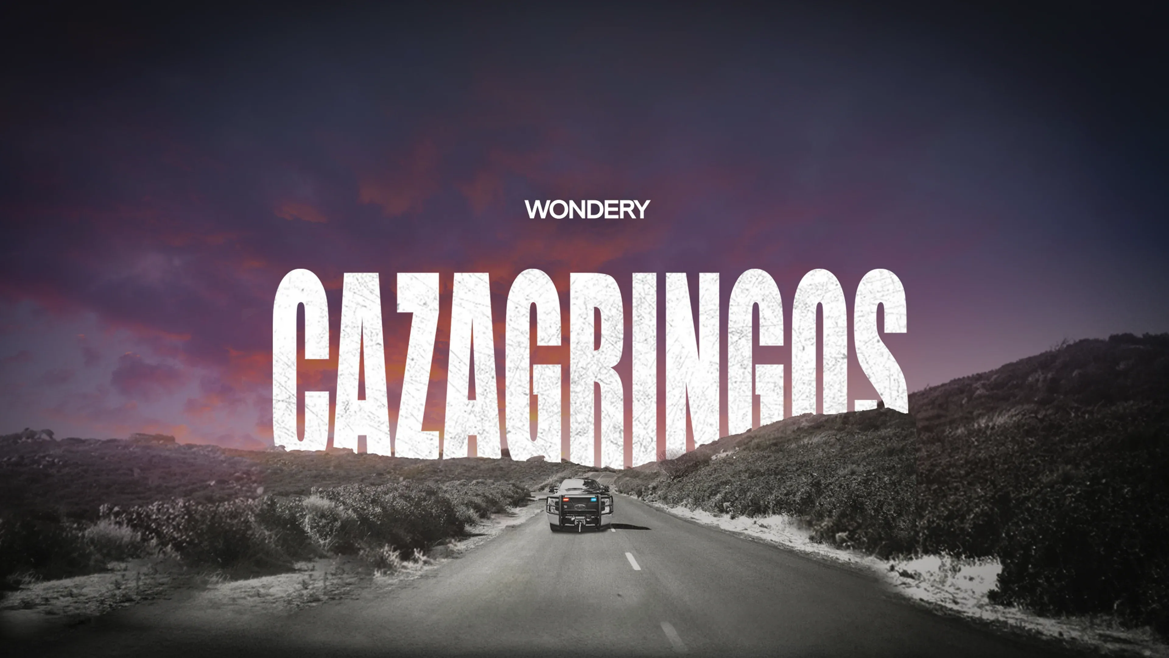 Cazagringos — una camioneta policial en una carretera del desierto al atardecer